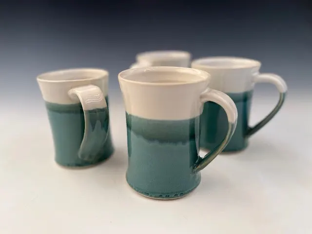 Four mugs glazed in teal and cream