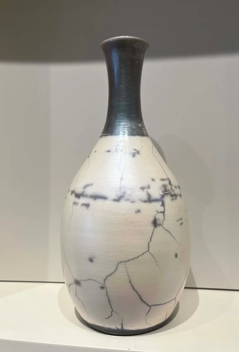White raku bottle vase with fine black horsehair crackle and a dark neck