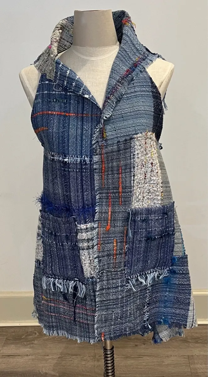Woven patchwork vest in blues and greys on a dress form
