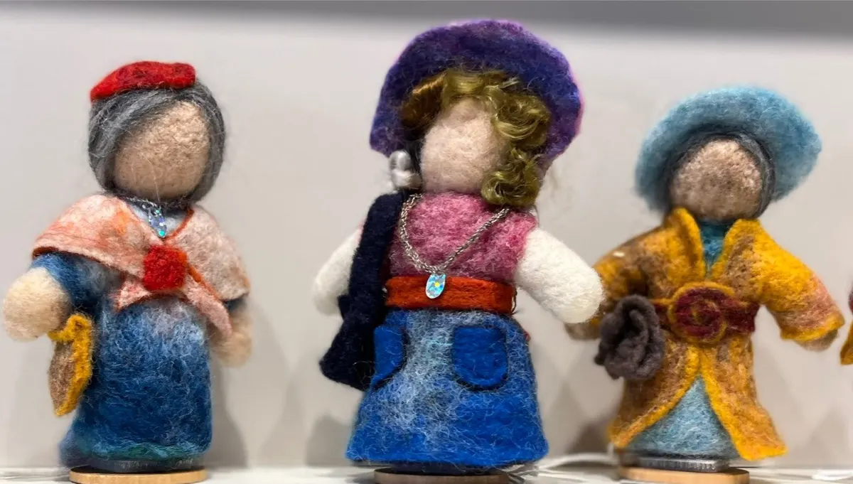 Three needle-felted figures in coloured robes and hats