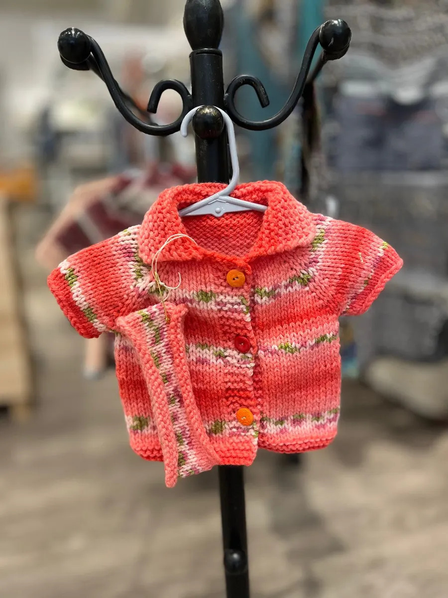 Coral hand-knitted baby cardigan with embroidered flowers