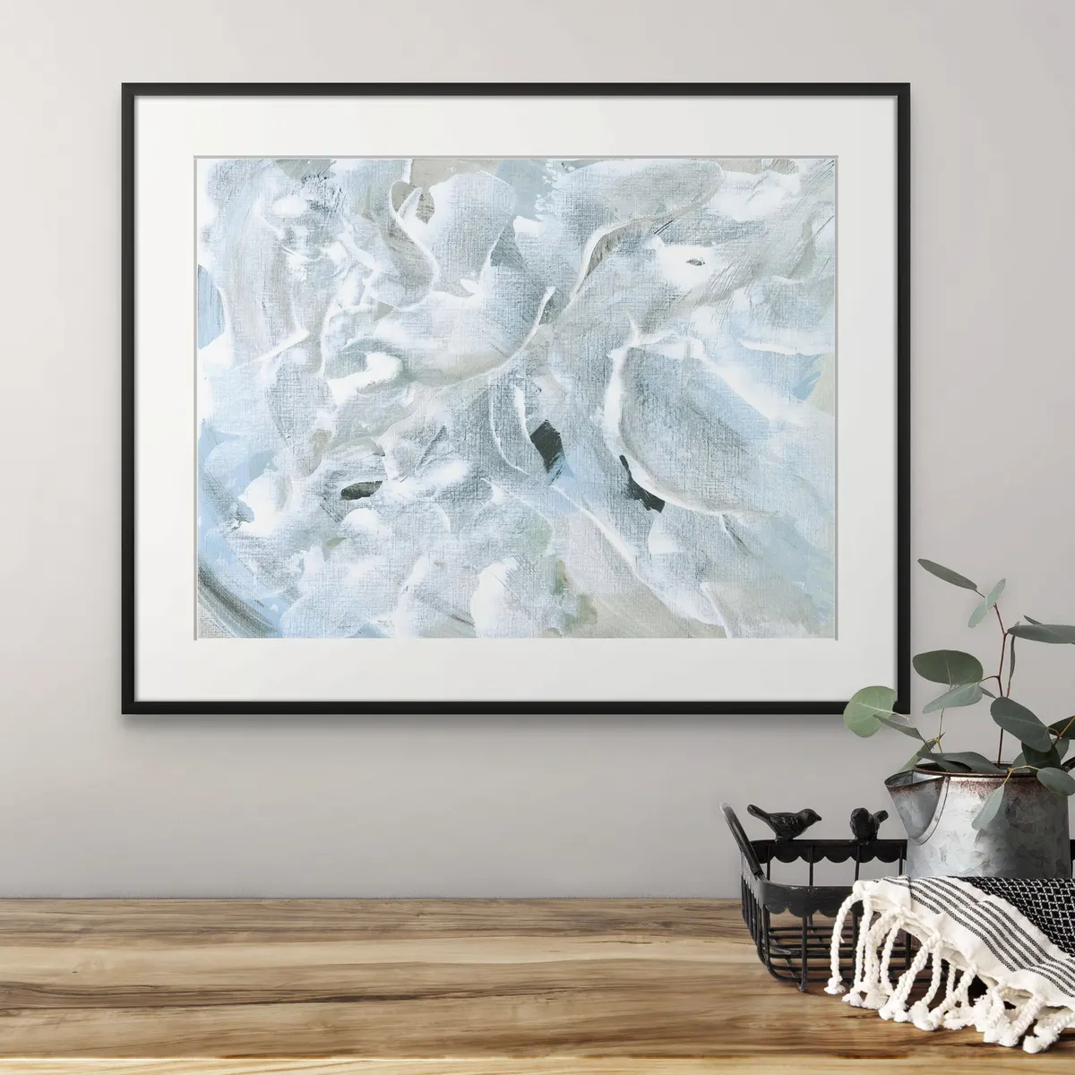 Large framed abstract in pale blue and white above a wooden table