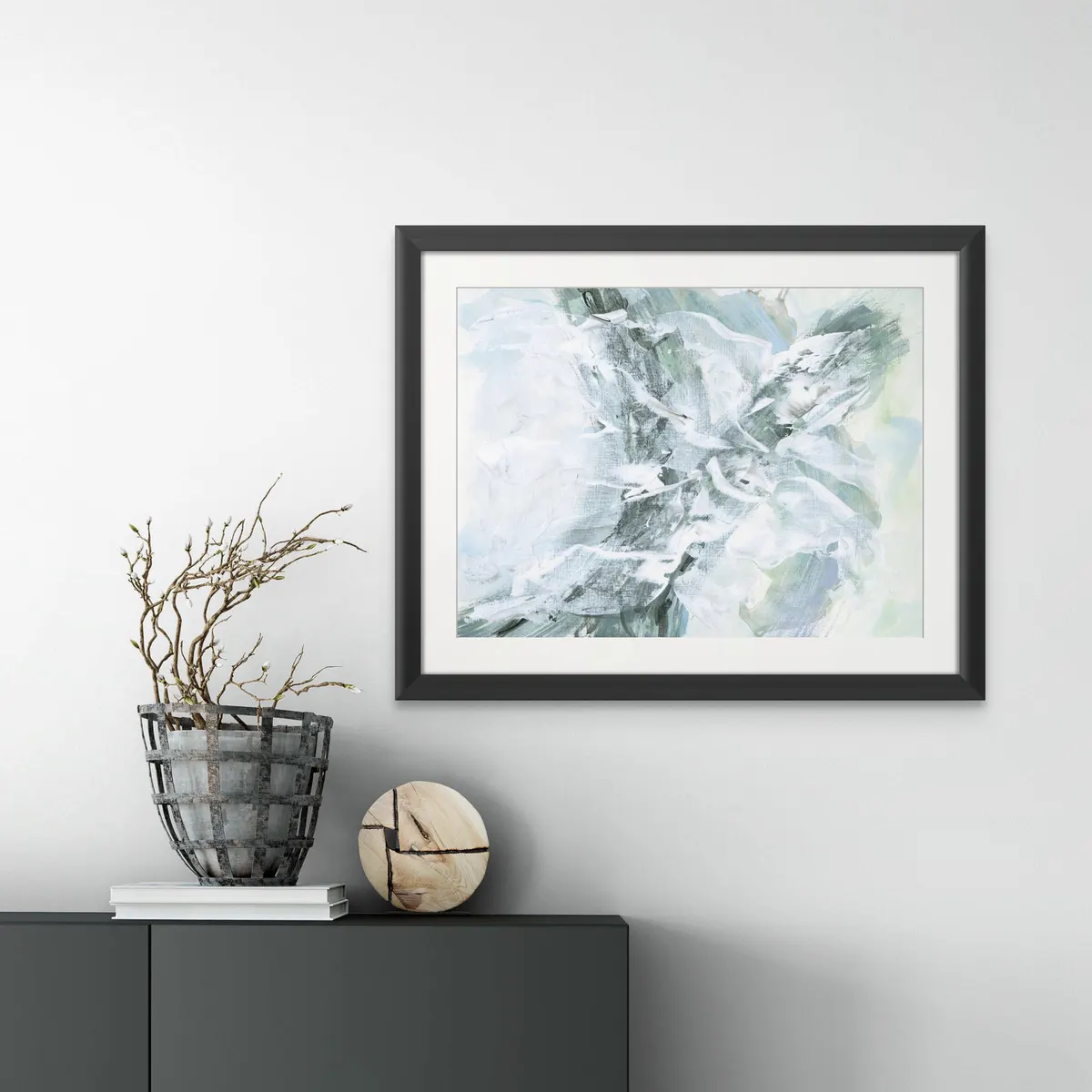 Framed abstract in soft greens and greys above a dark sideboard