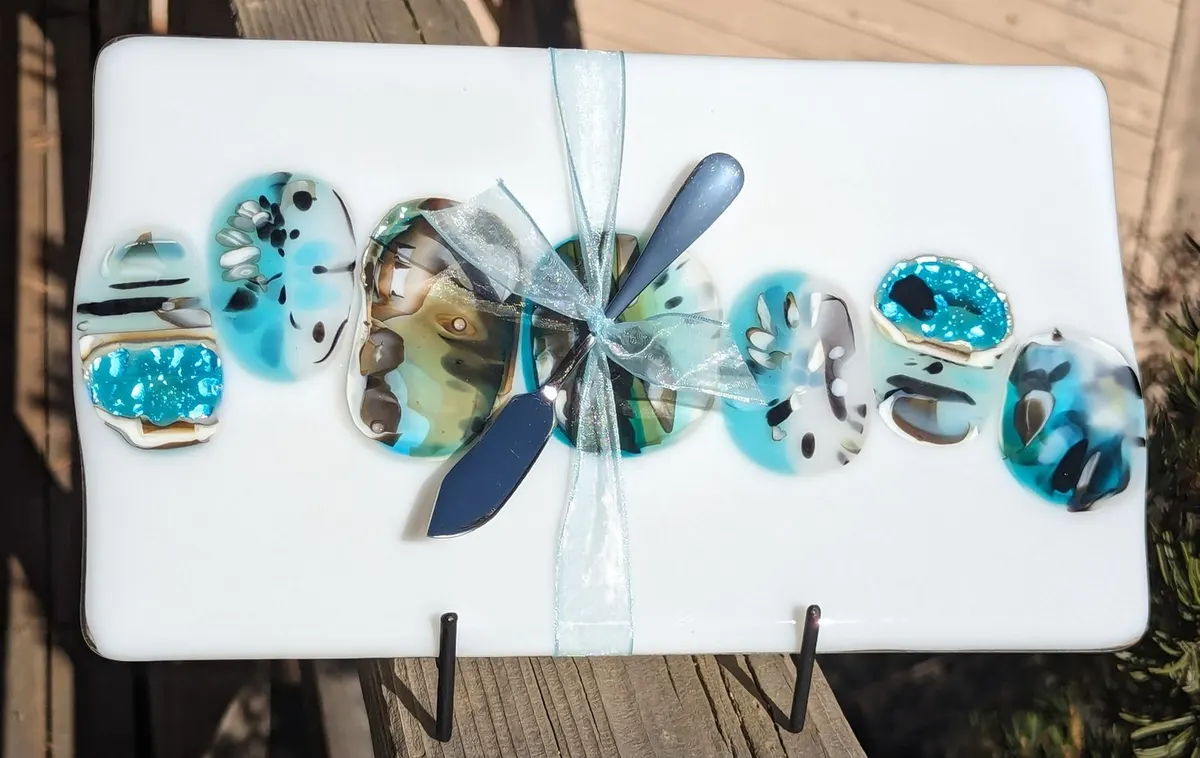 White fused glass tray with a row of turquoise and silver discs and a dragonfly