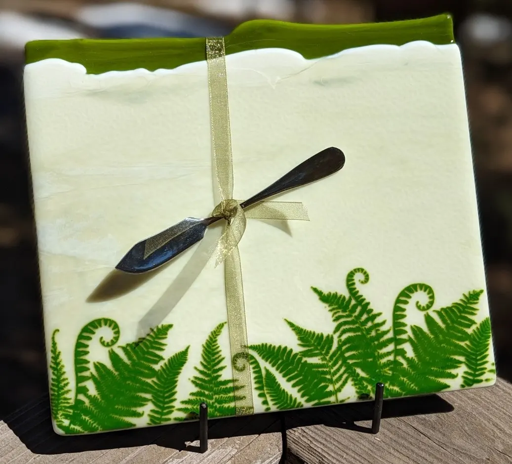 Cream fused glass panel with green ferns and a dragonfly on a gold ribbon