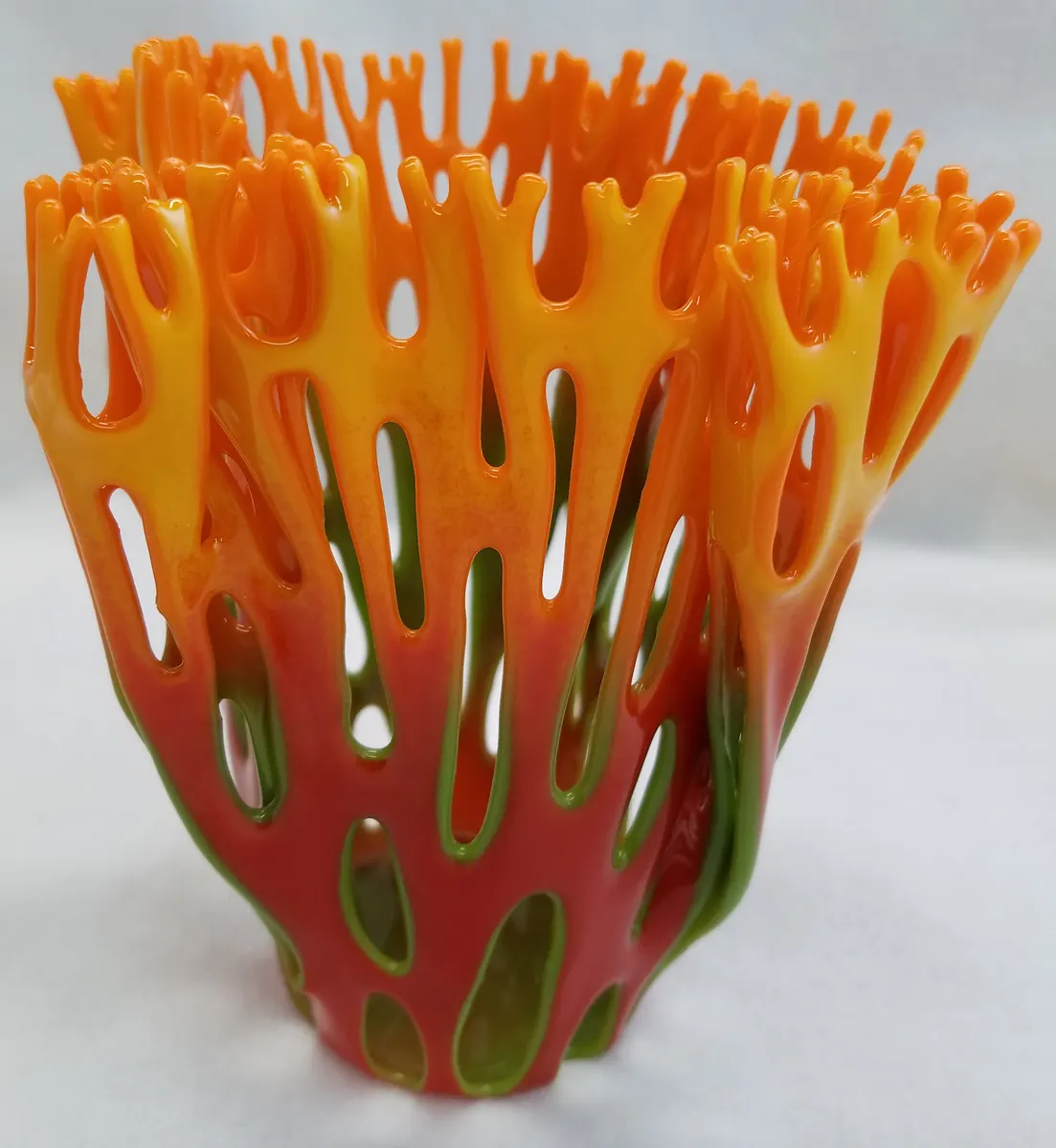 Openwork fused glass vase in orange and red resembling branching coral