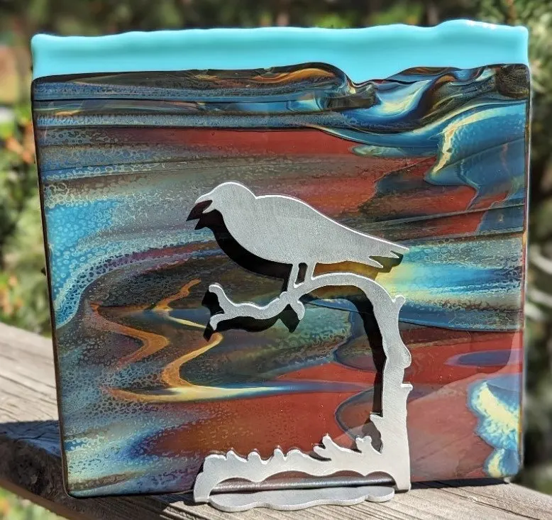 Fused glass panel in sunset colours with a silver bird on a branch