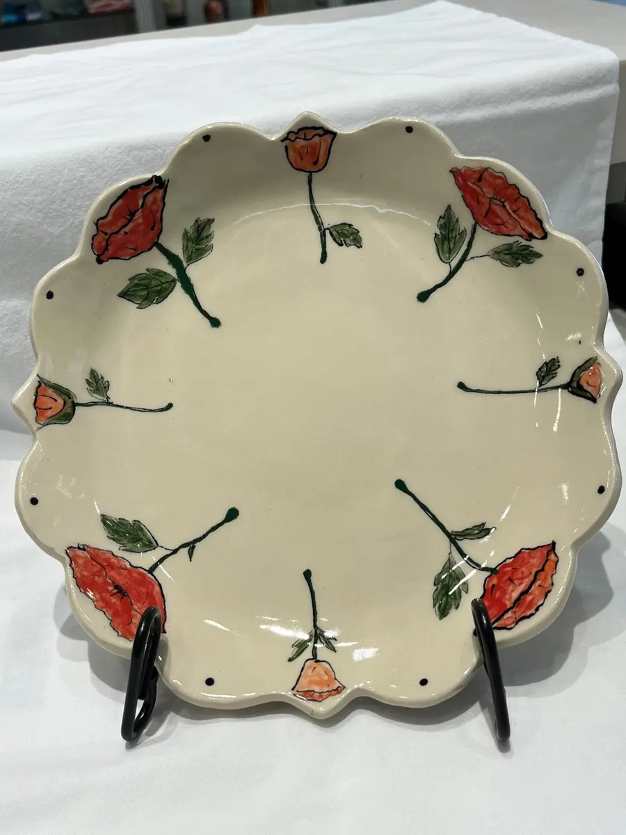 Scalloped cream plate painted with red poppies on trailing stems
