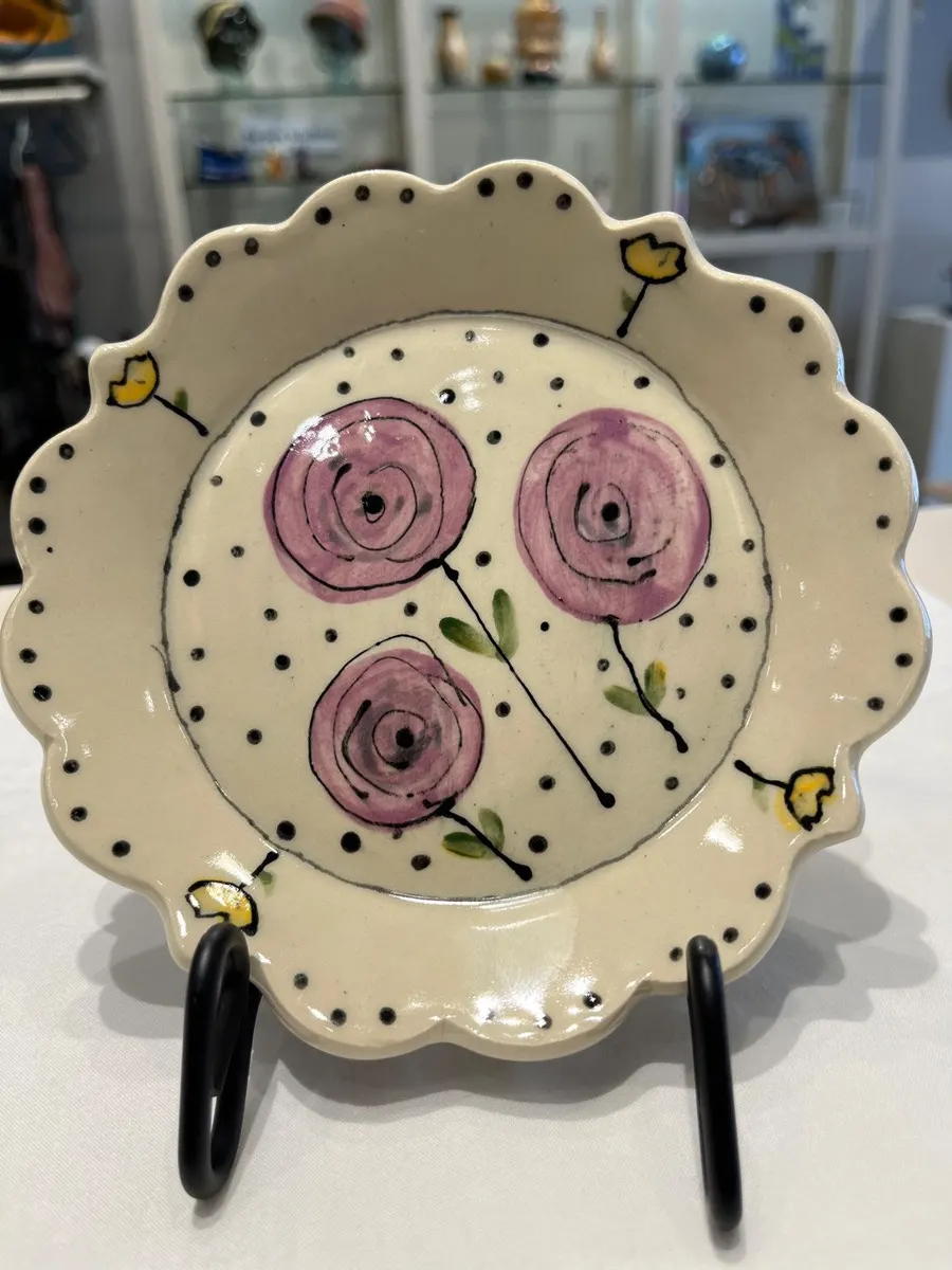 Scalloped dish painted with pink ranunculus inside a dotted border