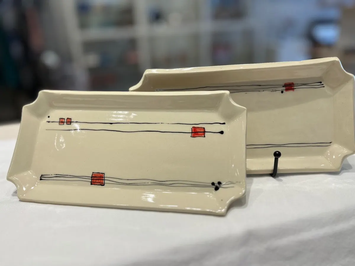 Two rectangular serving trays with fine line and red square decoration