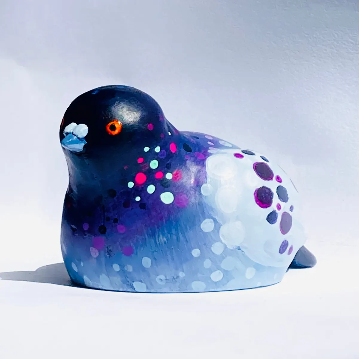 Painted bird figurine in navy and pale blue with coloured dots