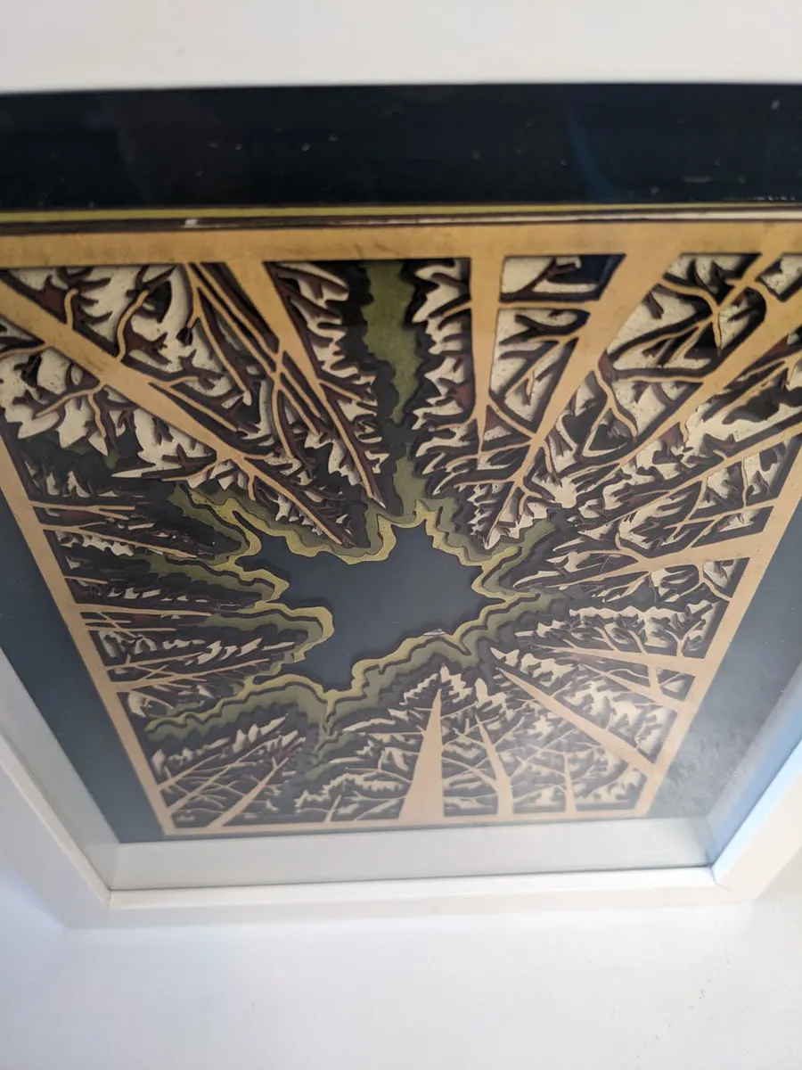 Layered laser-cut canopy design in gold and black, viewed from below