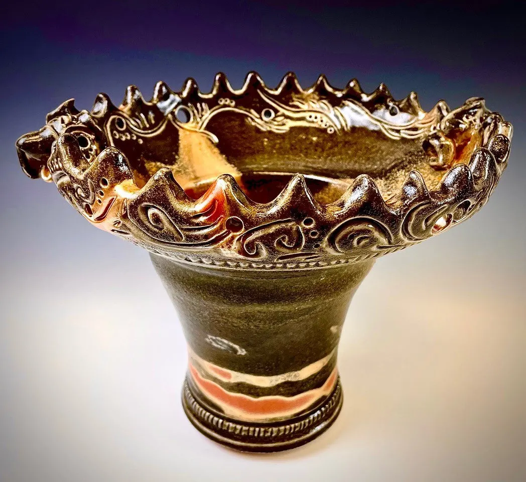 Footed vessel with a ruffled rim in olive and amber with carved detail