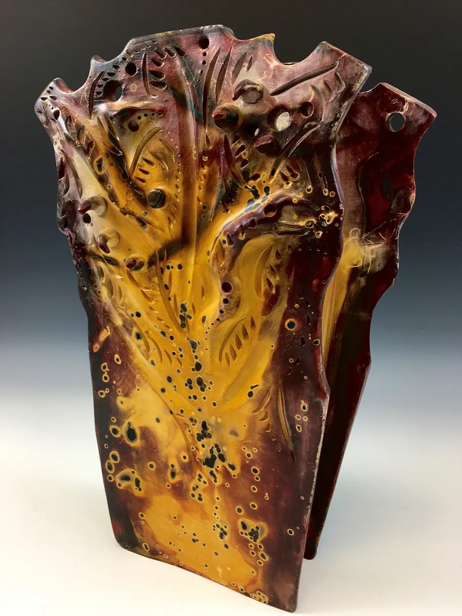Tall angular vessel with a torn, folded profile in amber and dark red
