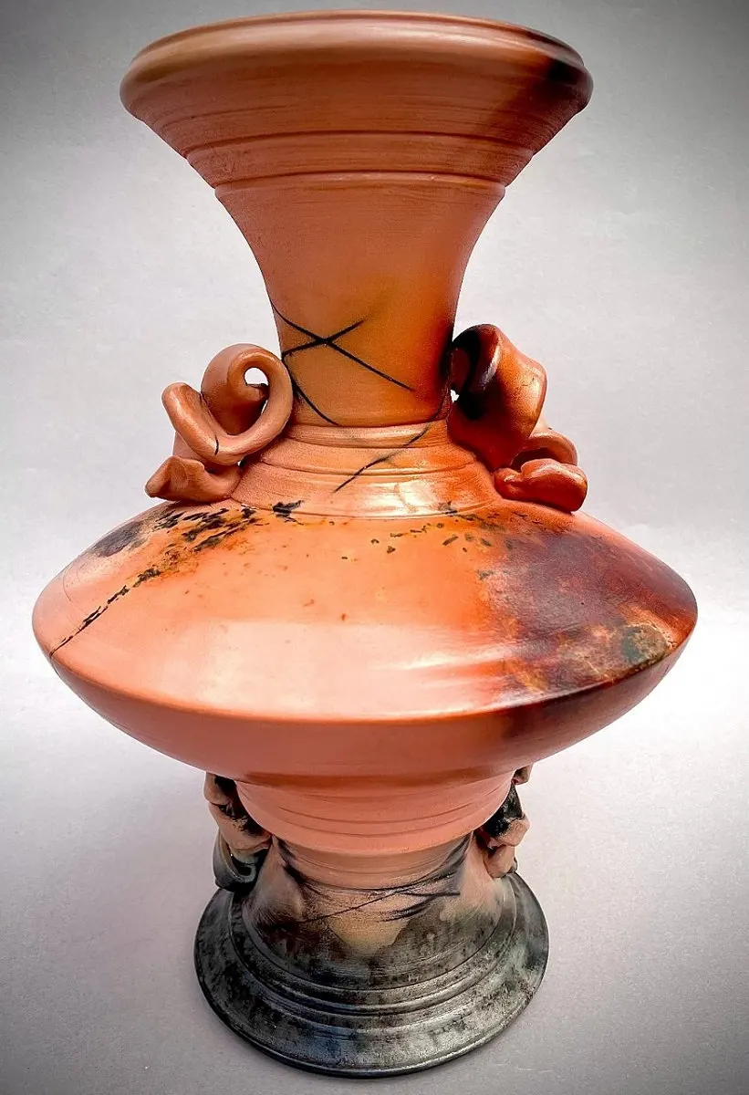 Wide-bellied vessel in terracotta with a flared neck and applied scrolls