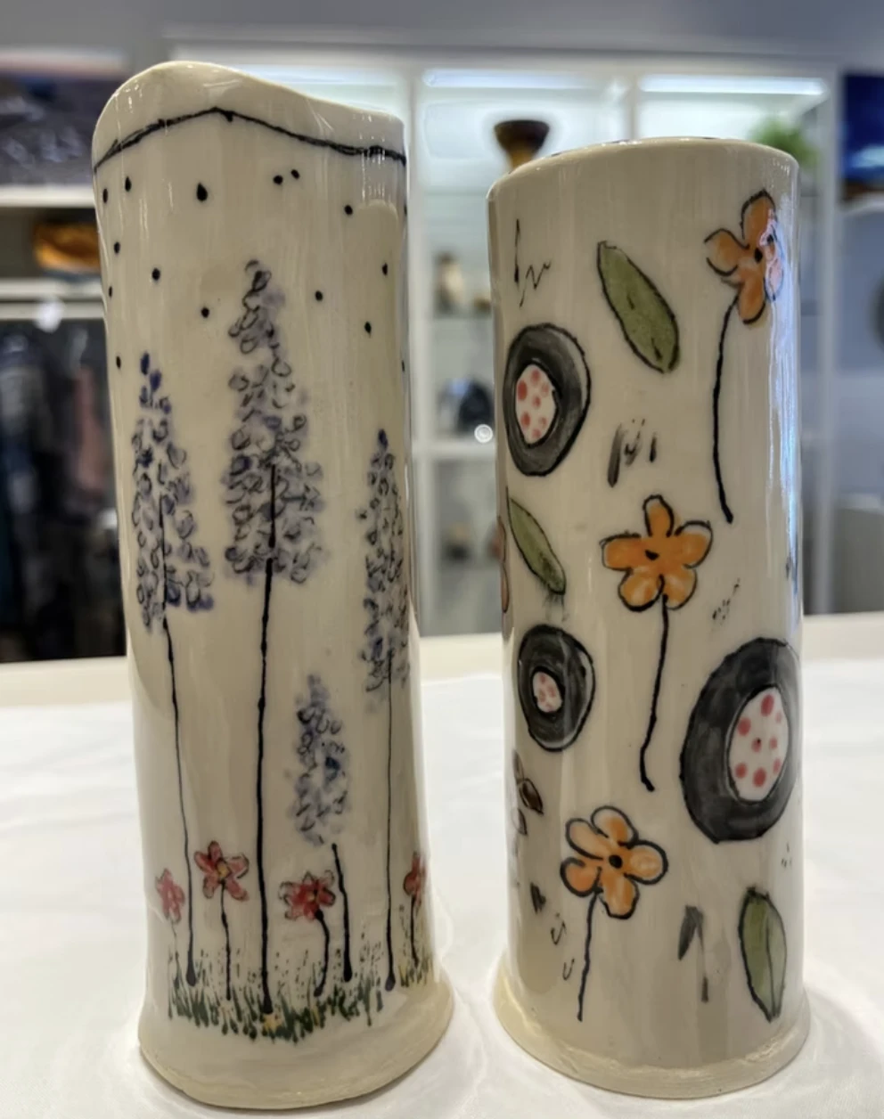 Pair of hand-painted ceramic vases with trees and flowers