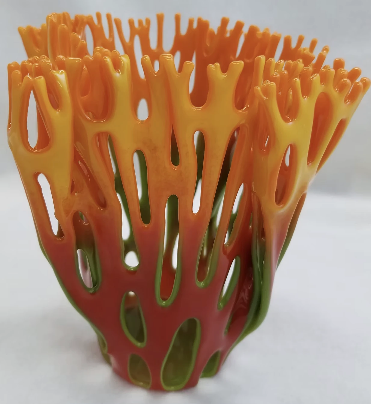 Openwork fused-glass vase in orange, yellow, and green
